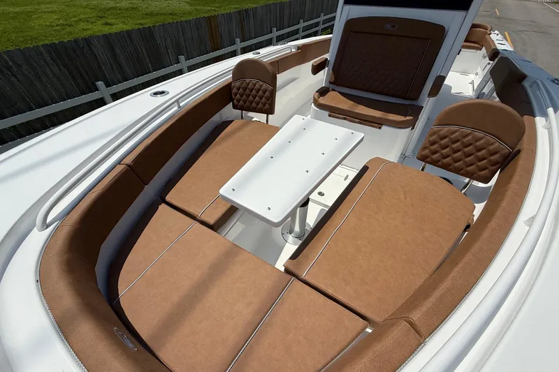 Slide: The Image of 2026 Sea Hunt Ultra 305 SE boat interior with brown seating and white table. - 20
