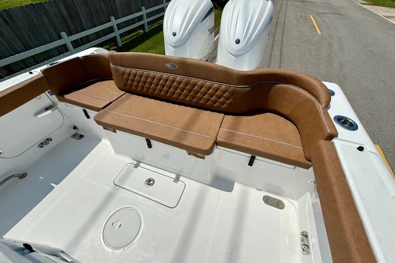 Slide: The Image of 2026 Sea Hunt Ultra 305 SE boat interior with brown cushioned seating. - 7