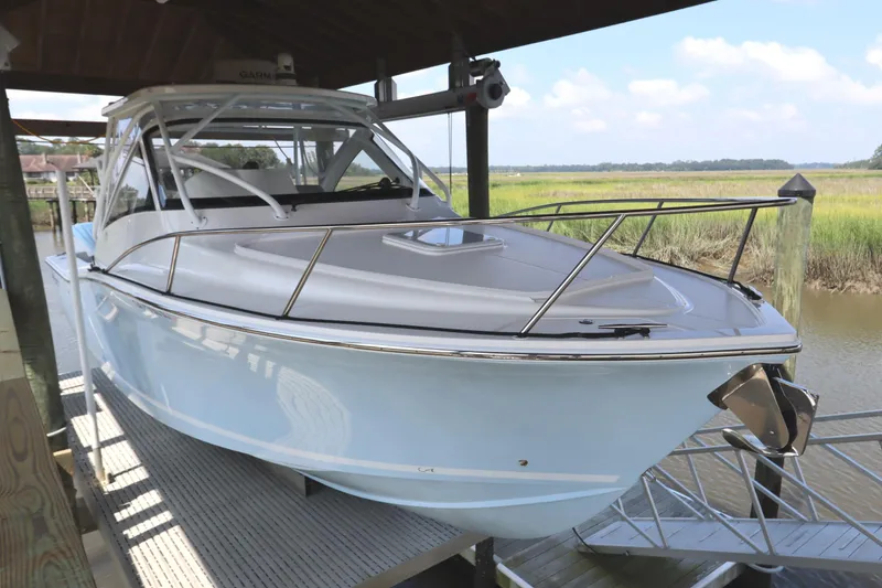 Slide: The Image of 2024 Albemarle 30 Express boat on lift, sheltered dock setting. - 1