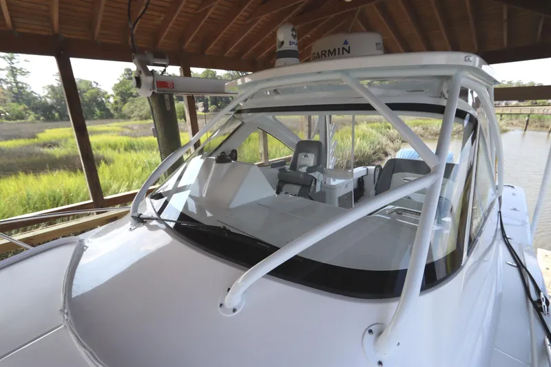 Slide: The Image of 2024 Albemarle 30 Express boat docked under a shelter, showcasing sleek design and fishing rod holders. - 12