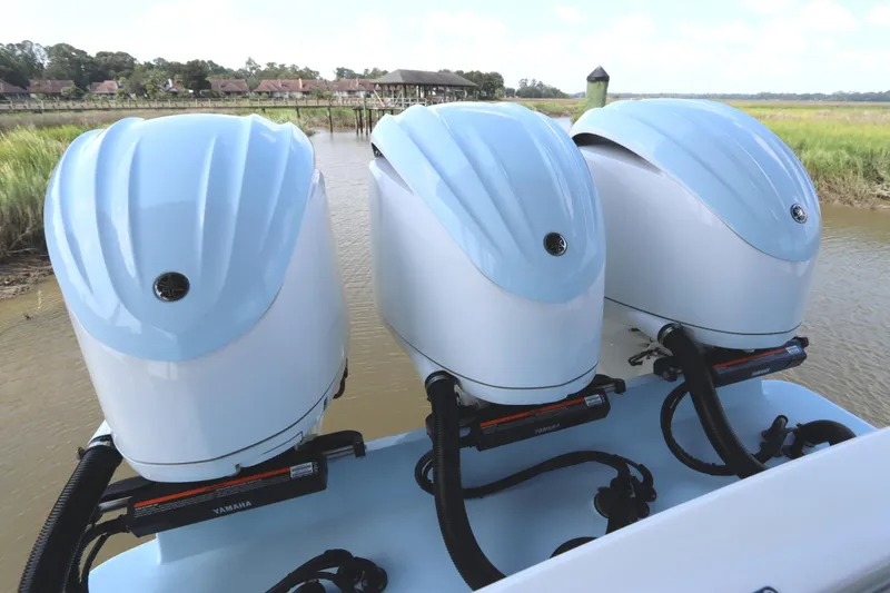 Slide: The Image of 2024 Albemarle 30 Express boat with triple outboard engines on a calm river. - 26