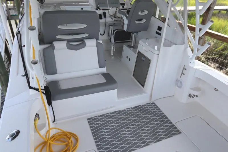 Slide: The Image of 2024 Albemarle 30 Express boat interior with seating and helm, docked by the water. - 36