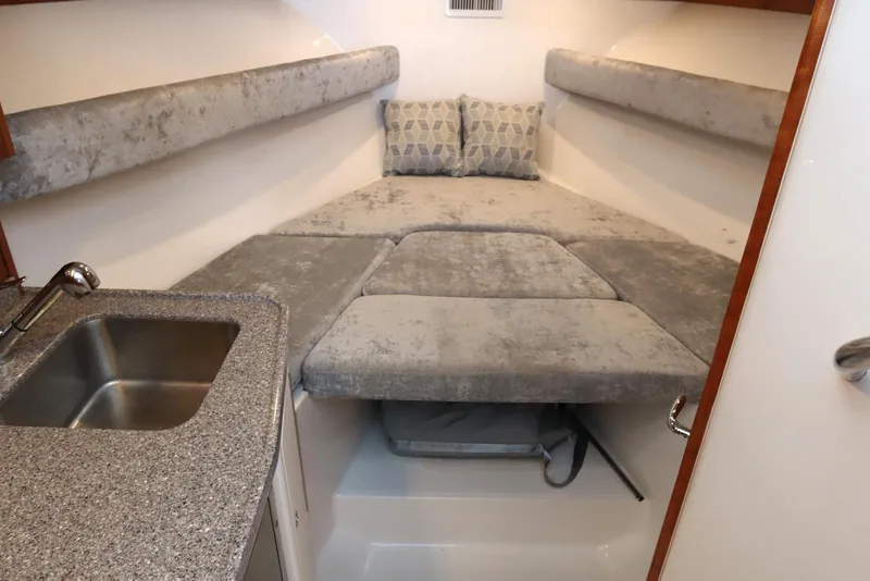 Slide: The Image of 2024 Albemarle 30 Express cabin interior with kitchenette, seating, and wooden cabinetry. - 72