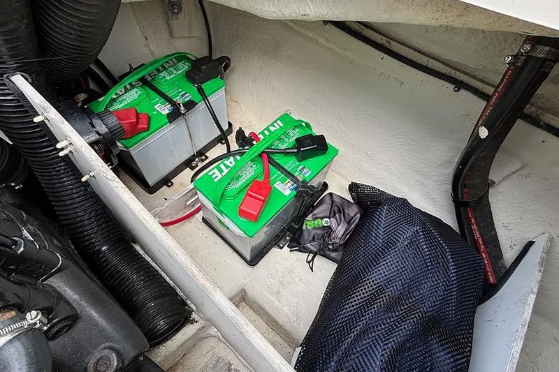 Slide: The Image of 2008 Sea Ray 185 Sport boat battery compartment with two green batteries. - 12