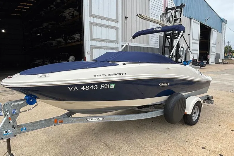 Slide: The Image of 2008 Sea Ray 185 Sport boat on trailer, parked outside a large garage. - 3