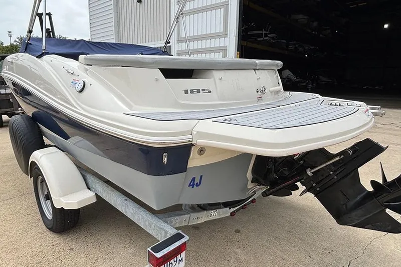 Slide: The Image of 2008 Sea Ray 185 Sport boat on trailer, rear view, parked near a garage. - 4