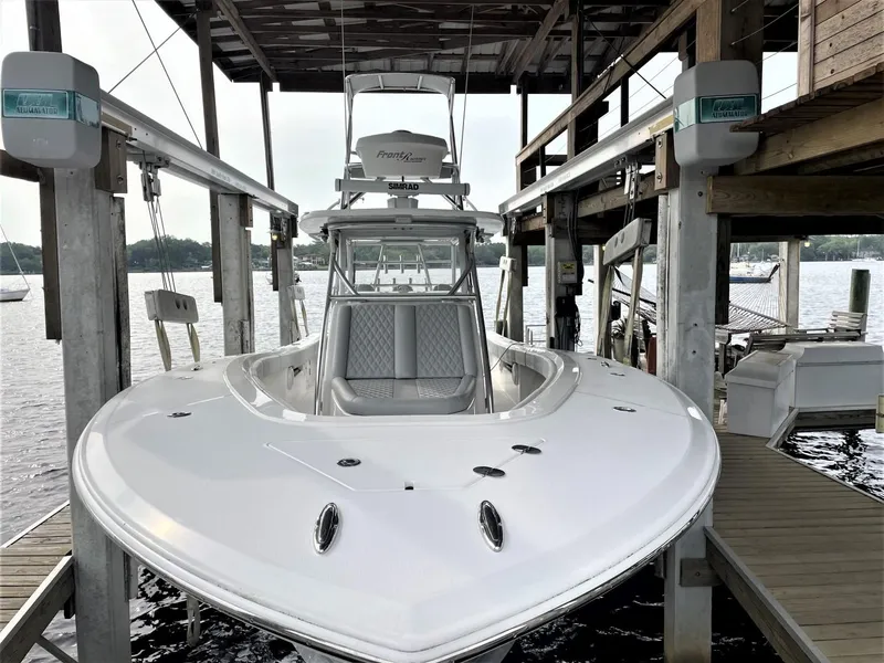 Slide: The Image of 2020 Front Runner 39 Center Console boat docked under a wooden shelter. - 12