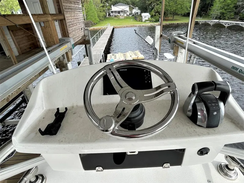 Slide: The Image of 2020 Front Runner 39 Center Console helm with steering wheel and controls, dockside view. - 25