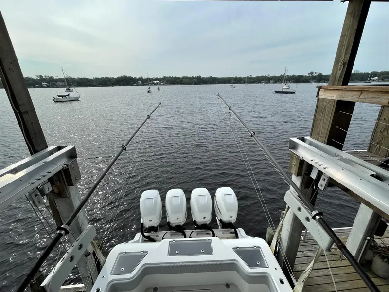 Slide: The Image of 2020 Front Runner 39 Center Console boat with four engines docked by a lake. - 26