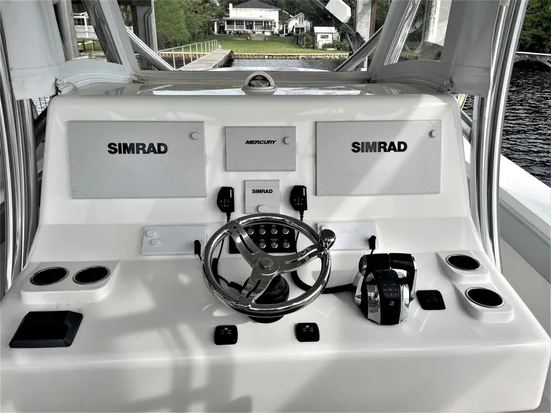 Slide: The Image of 2020 Front Runner 39 Center Console boat dashboard with Simrad displays and Mercury controls. - 28