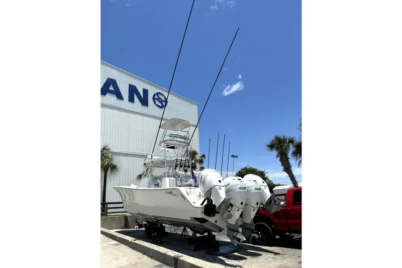 Slide: The Image of 2020 Front Runner 39 Center Console boat with multiple engines, parked near a building. - 4