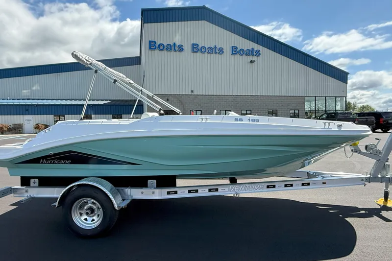 The Image of 2026 Hurricane SunDeck Sport 185 OB boat on trailer outside dealership. - 0