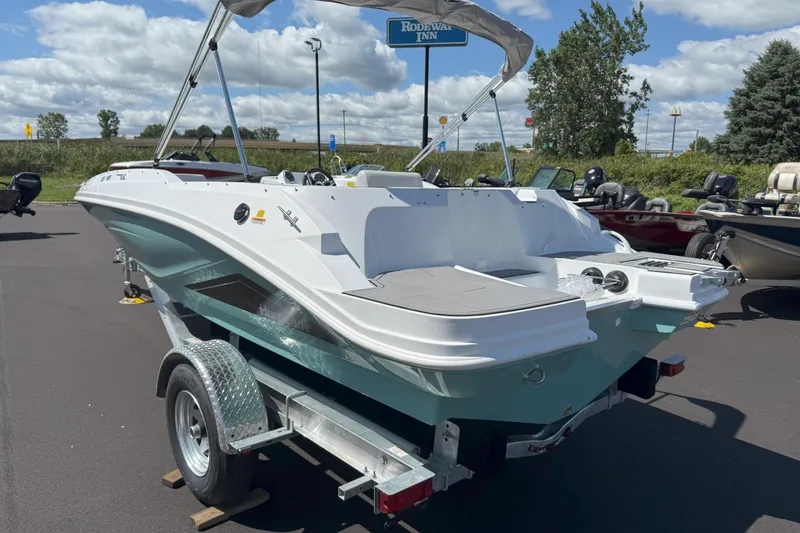 Slide: The Image of 2026 Hurricane SunDeck Sport 185 OB boat on trailer, parked outdoors under blue sky. - 5
