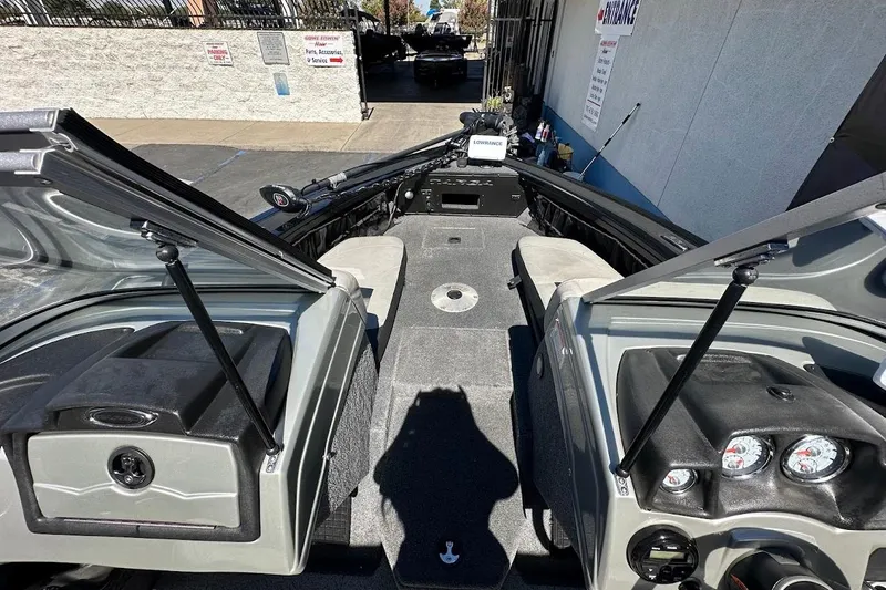 Slide: The Image of 2018 Tracker Targa V-19 Combo boat interior with open compartments and dashboard view. - 23