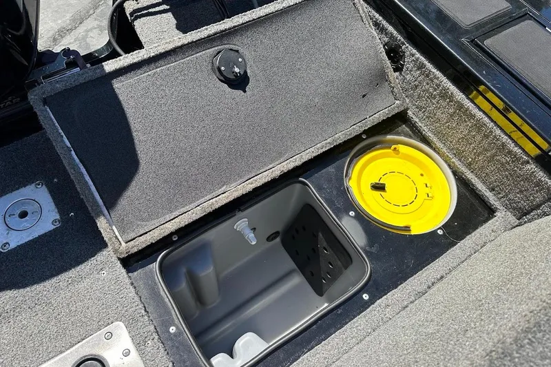 Slide: The Image of 2018 Tracker Targa V-19 Combo boat storage compartment with yellow lid and gray interior. - 36