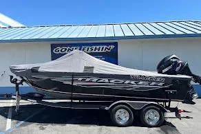 Slide: The Image of 2018 Tracker Targa V-19 Combo boat with cover on trailer, parked outside. - 40