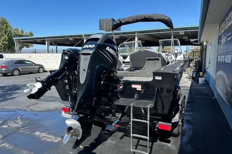 Slide: The Image of 2018 Tracker Targa V-19 Combo boat with Mercury 200 engine, parked outdoors. - 9