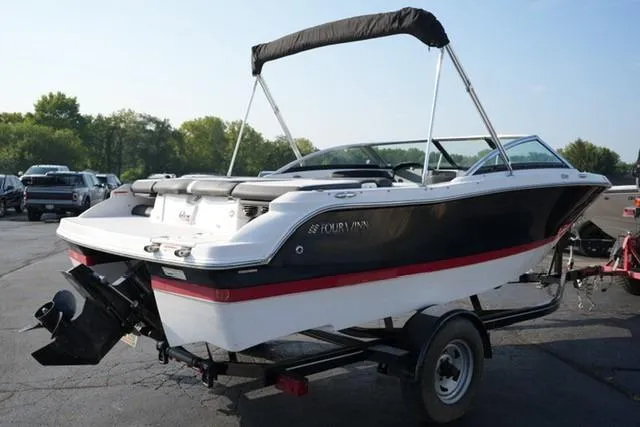 Slide: The Image of 2013 Four Winns H190 boat on trailer, black and white design, parked outdoors. - 4