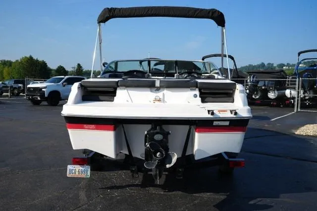 Slide: The Image of 2013 Four Winns H190 boat, rear view, parked in a lot under clear blue sky. - 5