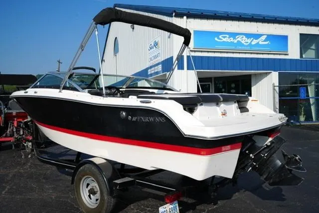 Slide: The Image of 2013 Four Winns H190 boat on trailer, parked outside a marine dealership. - 6
