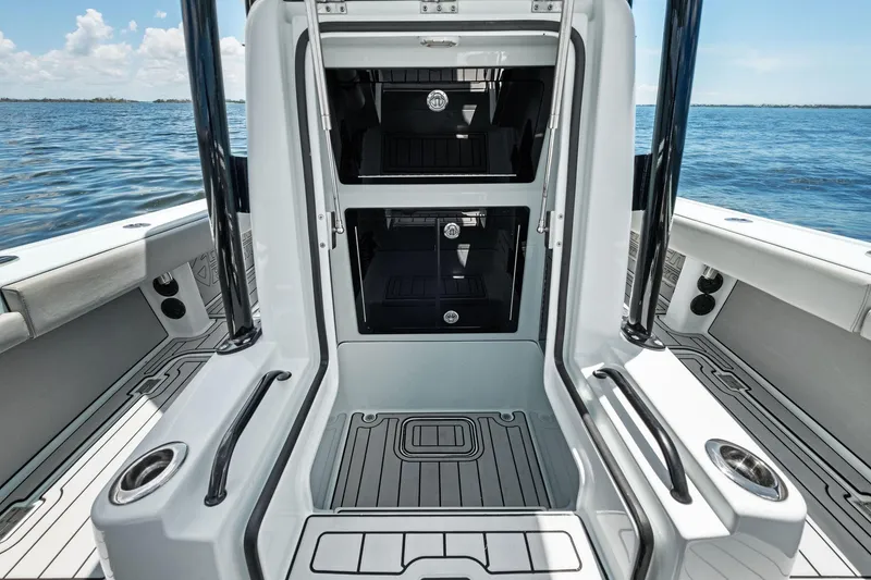 Slide: The Image of 2020 Barker Boatworks 26 Open interior with storage compartments, sleek design, and ocean backdrop. - 17