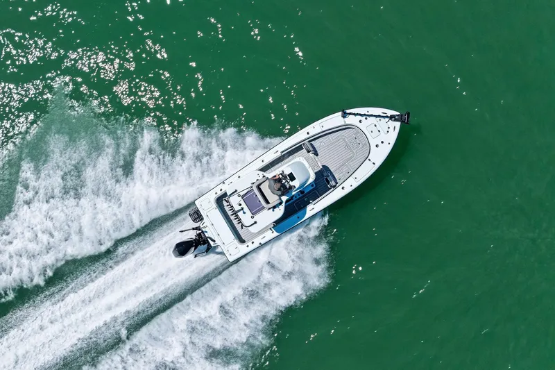 Slide: The Image of Aerial view of 2020 Barker Boatworks 26 Open speeding on green water. - 28