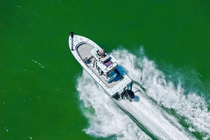 Slide: The Image of Aerial view of 2020 Barker Boatworks 26 Open speeding on green water. - 27