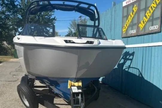 Slide: The Image of 2026 Yamaha Boats AR220 on trailer, parked outdoors near blue fence. - 1