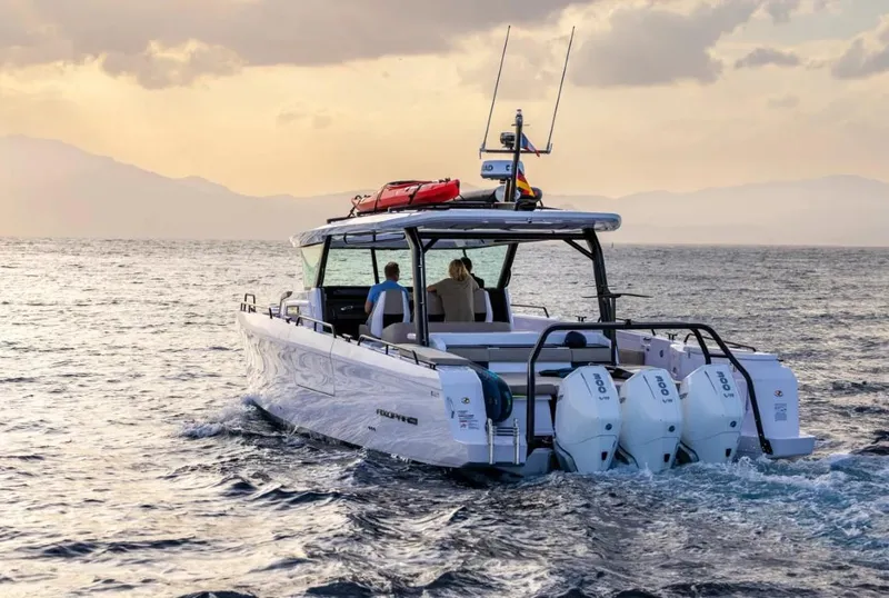 Slide: The Image of 2025 Axopar 45 Cross Top boat cruising on open water at sunset. - 4