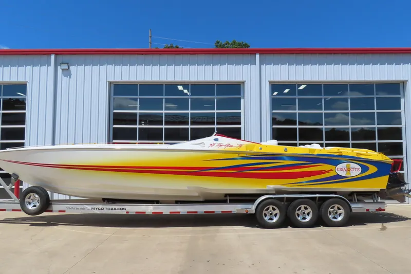 Slide: The Image of 2003 Cigarette 38 Top Gun speedboat with vibrant yellow and red design on a trailer. - 1