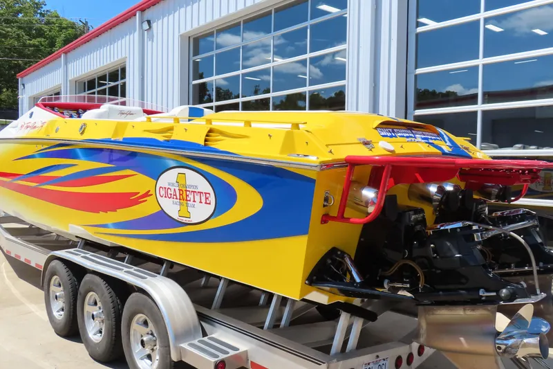 Slide: The Image of 2003 Cigarette 38 Top Gun speedboat with vibrant yellow and blue design on a trailer. - 10
