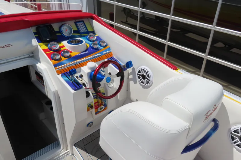 Slide: The Image of 2003 Cigarette 38 Top Gun boat cockpit with colorful dashboard and white seating. - 16