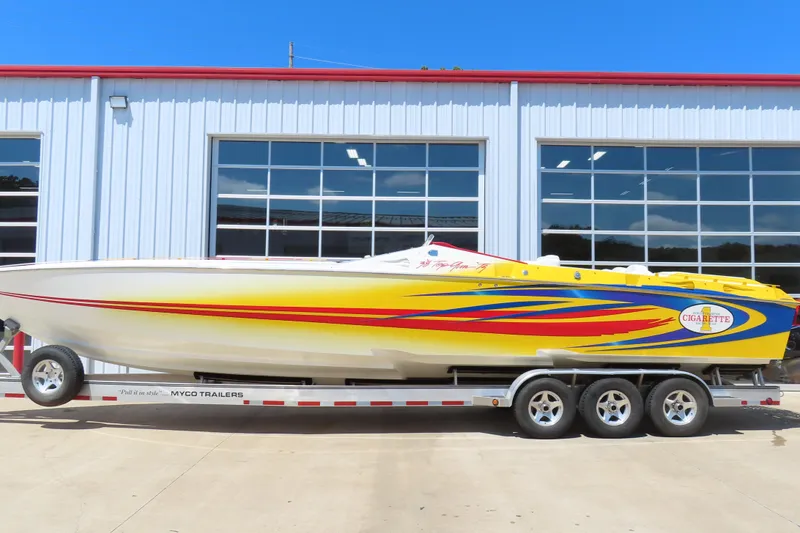 Slide: The Image of 2003 Cigarette 38 Top Gun speedboat with vibrant yellow and red design on a trailer. - 2