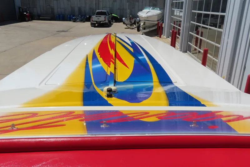 Slide: The Image of 2003 Cigarette 38 Top Gun boat with vibrant, colorful graphics in a marina setting. - 22