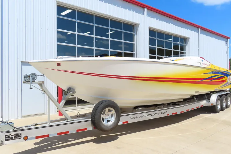 Slide: The Image of 2003 Cigarette 38 Top Gun boat on trailer outside a garage. - 3