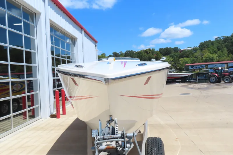 Slide: The Image of 2003 Cigarette 38 Top Gun boat on trailer, parked outside a garage under blue sky. - 4