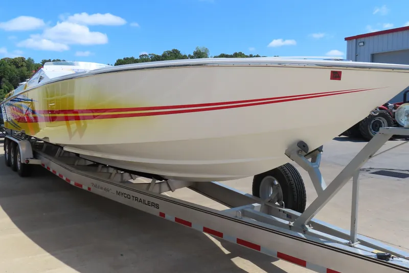 Slide: The Image of 2003 Cigarette 38 Top Gun speedboat on trailer, featuring vibrant red and yellow graphics. - 6