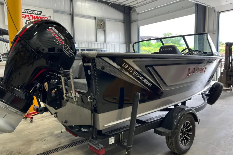 Slide: The Image of 2026 Lund 1875 Fisherman boat with Mercury Pro XS engine in a garage setting. - 2