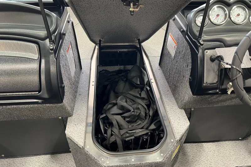 Slide: The Image of 2026 Lund 1875 Fisherman boat interior storage compartment with open lid and gauges. - 24
