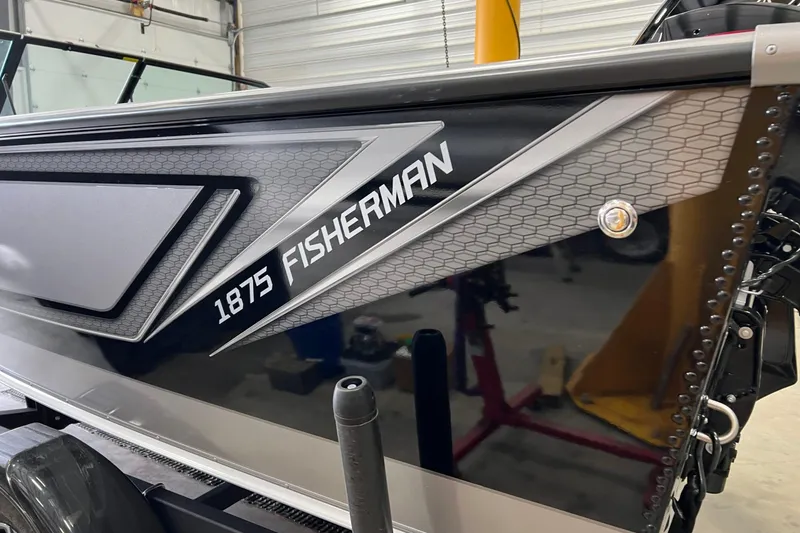 Slide: The Image of 2026 Lund 1875 Fisherman boat side view in a garage setting. - 7