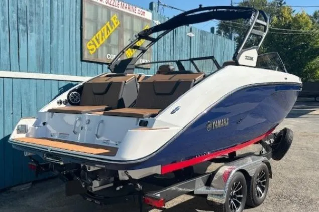 Slide: The Image of 2026 Yamaha Boats 222SE on trailer, blue and white design, parked outdoors. - 2