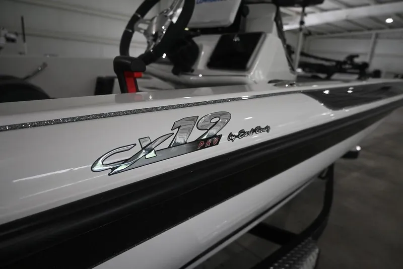 Slide: The Image of 2026 Caymas CX19 PRO boat, close-up of logo and sleek design in showroom. - 3