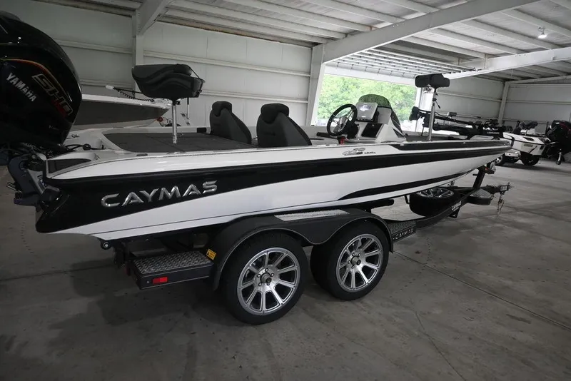 Slide: The Image of 2026 Caymas CX19 PRO boat in a showroom, featuring sleek design and dual-axle trailer. - 6