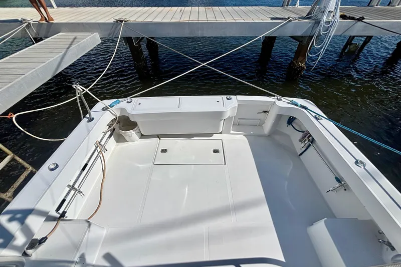 Slide: The Image of 2002 Luhrs 32 Open boat deck, docked with ropes, featuring spacious layout and clean design. - 12