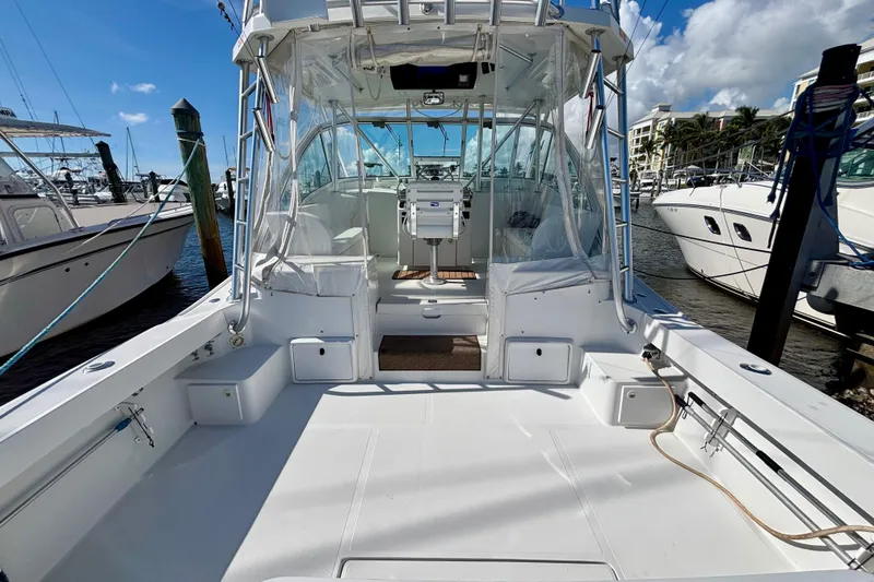 Slide: The Image of 2002 Luhrs 32 Open boat docked at marina, showcasing spacious deck and helm area. - 13