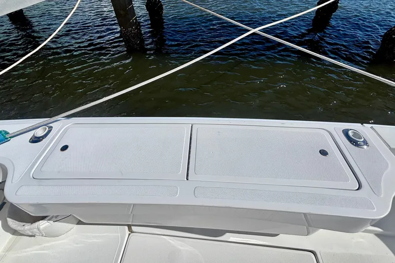 Slide: The Image of 2002 Luhrs 32 Open boat deck with storage compartments, docked by water. - 16