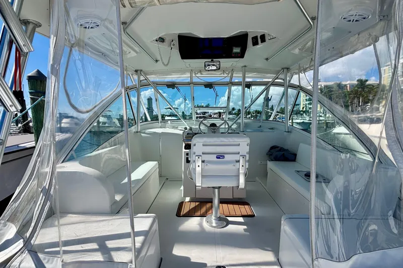 Slide: The Image of 2002 Luhrs 32 Open boat interior with helm, seating, and clear enclosures. - 19