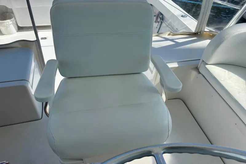 Slide: The Image of Captain's chair on 2002 Luhrs 32 Open boat, featuring white upholstery and armrests. - 24