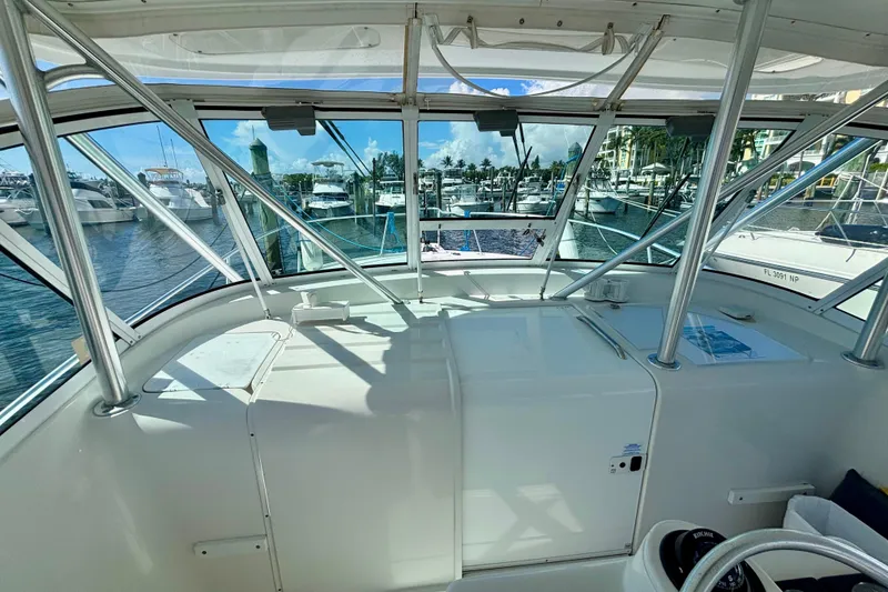Slide: The Image of 2002 Luhrs 32 Open boat interior with marina view, showcasing helm and seating area. - 28