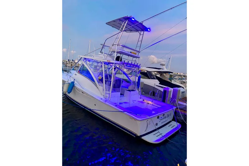 Slide: The Image of 2002 Luhrs 32 Open boat docked with blue LED lights at sunset. - 3